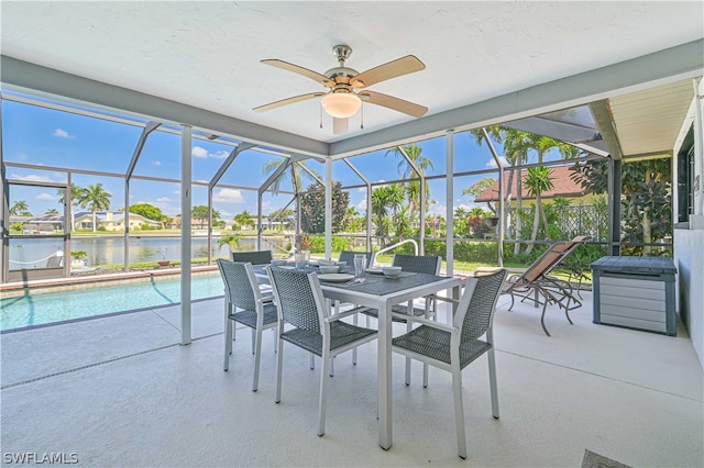 sunroom with a wealth of natural light, ceiling fan, a swimming pool, and a water view