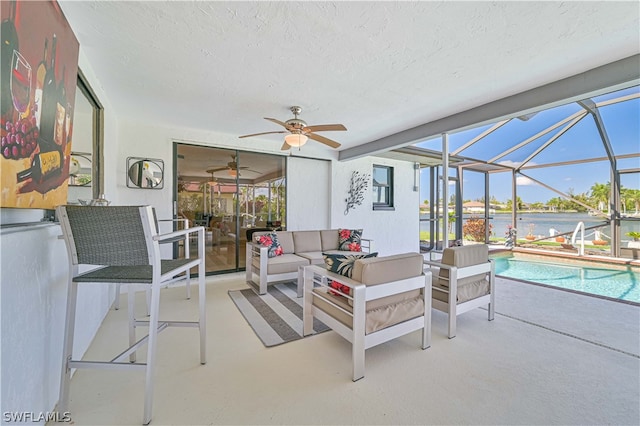 interior space featuring ceiling fan, a water view, and a swimming pool