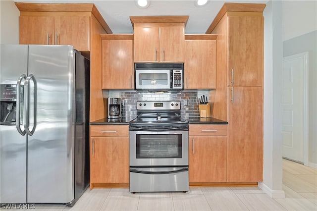 kitchen with decorative backsplash, stainless steel appliances, light tile patterned flooring, and dark stone countertops