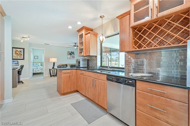 kitchen featuring kitchen peninsula, tasteful backsplash, sink, pendant lighting, and dishwasher