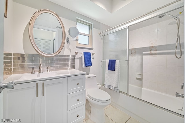 full bathroom with vanity, shower / bath combination with glass door, backsplash, tile patterned floors, and toilet