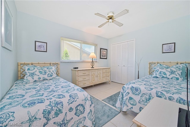 bedroom featuring ceiling fan, light tile patterned floors, and a closet