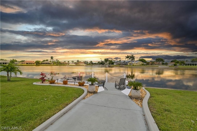 exterior space featuring a lawn and a water view