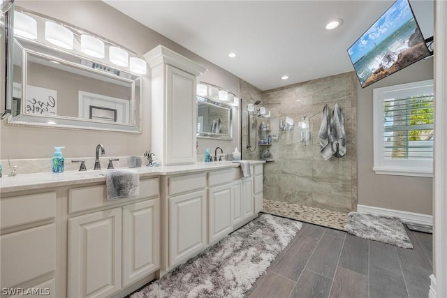 bathroom with vanity and a tile shower