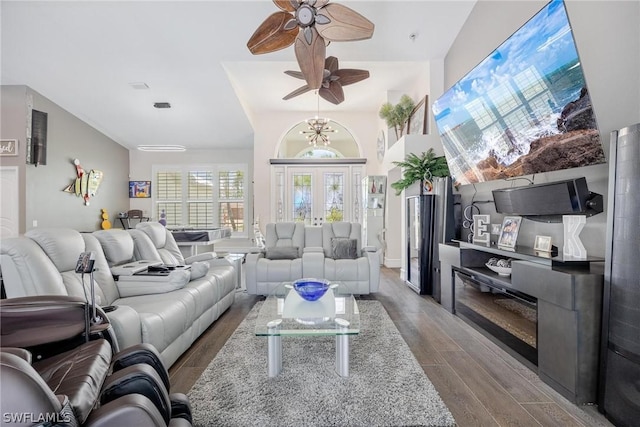 living room with hardwood / wood-style floors and ceiling fan with notable chandelier