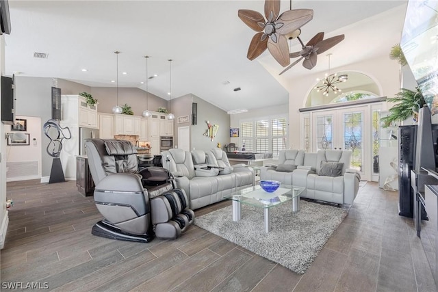 living room with ceiling fan with notable chandelier, dark hardwood / wood-style flooring, and high vaulted ceiling