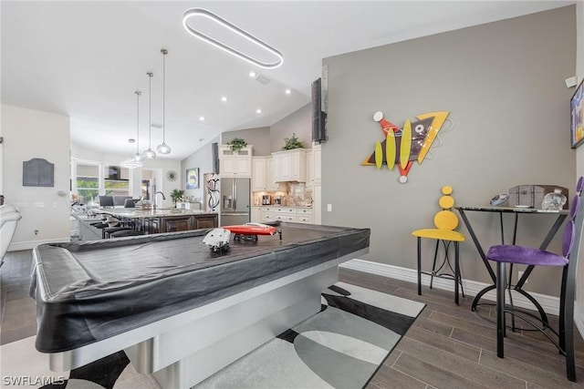 game room with dark hardwood / wood-style flooring, vaulted ceiling, and sink