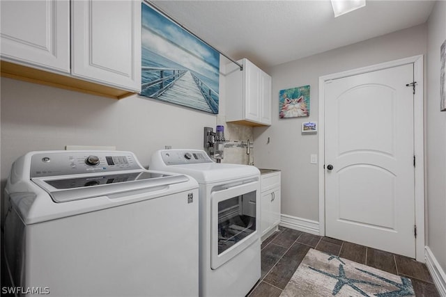 laundry room featuring cabinets, washing machine and dryer, and dark wood-type flooring