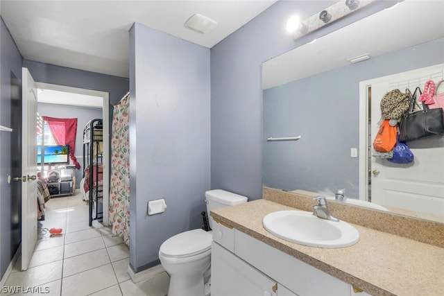 bathroom with tile flooring, toilet, and vanity with extensive cabinet space