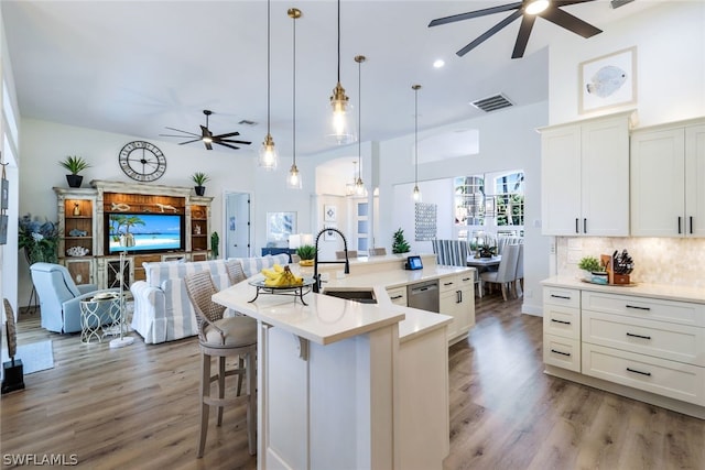 kitchen with ceiling fan, light hardwood / wood-style flooring, tasteful backsplash, and sink