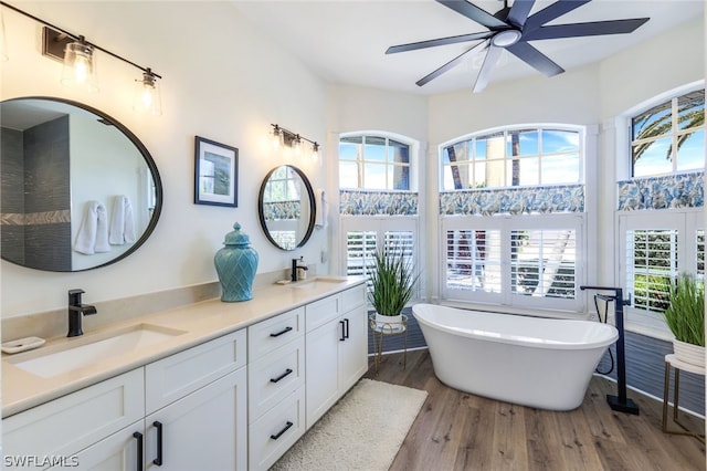 bathroom featuring plenty of natural light, ceiling fan, double sink vanity, and wood-type flooring