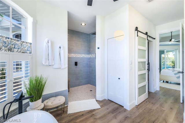 bathroom with shower with separate bathtub, wood-type flooring, ceiling fan, and french doors