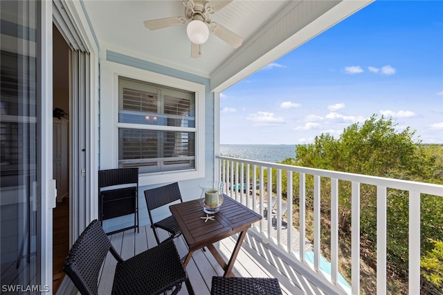 balcony with a water view and ceiling fan