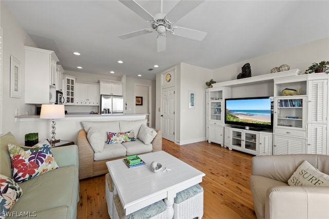 living room with ceiling fan and light wood-type flooring