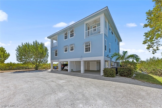 view of property exterior with a carport, a balcony, and central AC unit