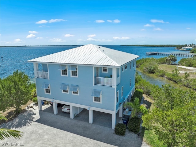 exterior space with a balcony, a carport, and a water view