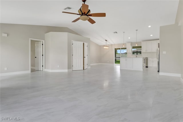 unfurnished living room with lofted ceiling and ceiling fan with notable chandelier