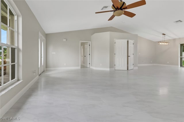 empty room with lofted ceiling and ceiling fan with notable chandelier