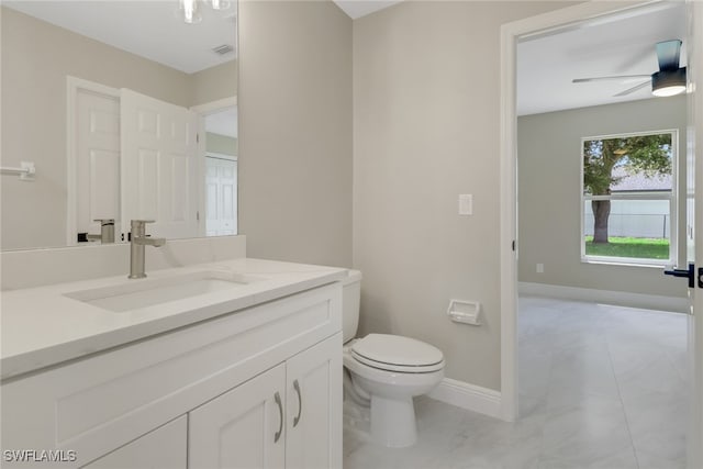 bathroom featuring vanity, toilet, and ceiling fan