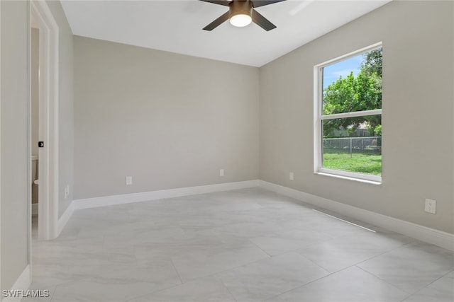 empty room featuring ceiling fan and a wealth of natural light