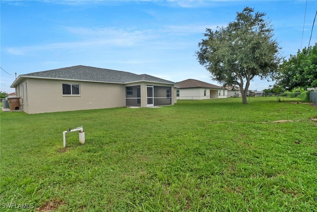 back of property with a lawn and a sunroom