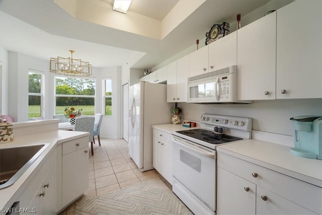 kitchen featuring light tile patterned floors, a tray ceiling, pendant lighting, white appliances, and white cabinets