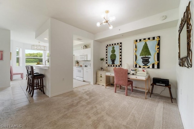 carpeted home office featuring a chandelier