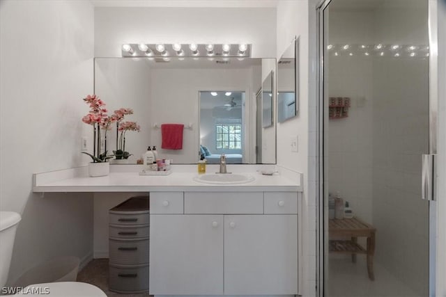 bathroom with walk in shower, vanity, ceiling fan, and toilet