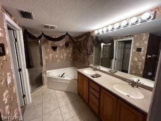 bathroom with vanity, a textured ceiling, separate shower and tub, and tile patterned floors