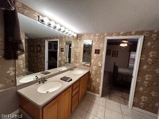 bathroom with vanity, tile patterned flooring, and a textured ceiling