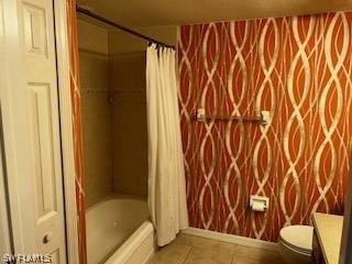 full bathroom featuring shower / bath combo with shower curtain, tile patterned floors, vanity, and toilet