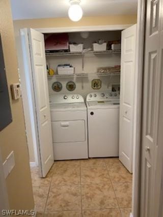 clothes washing area with washing machine and clothes dryer and light tile patterned floors