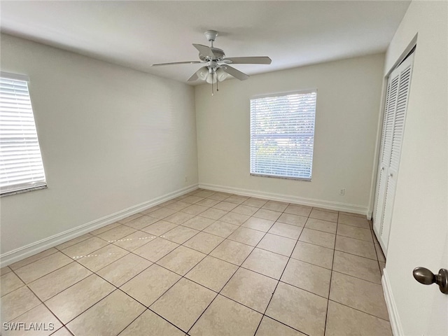 spare room featuring light tile patterned floors and ceiling fan