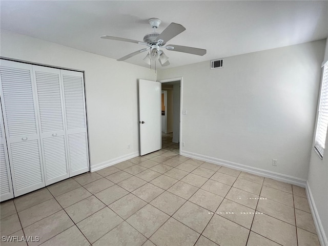 unfurnished bedroom featuring ceiling fan, a closet, and light tile patterned floors