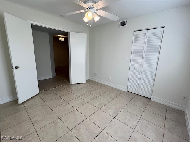 unfurnished bedroom featuring ceiling fan, light tile patterned floors, and a closet