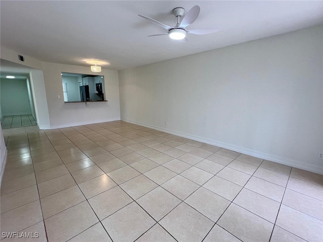 tiled spare room with ceiling fan