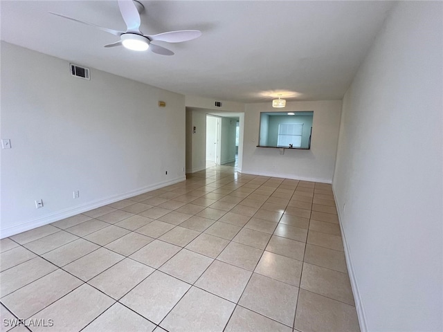 spare room with ceiling fan and light tile patterned flooring