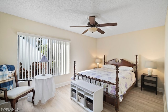 bedroom with a textured ceiling, light hardwood / wood-style flooring, and ceiling fan