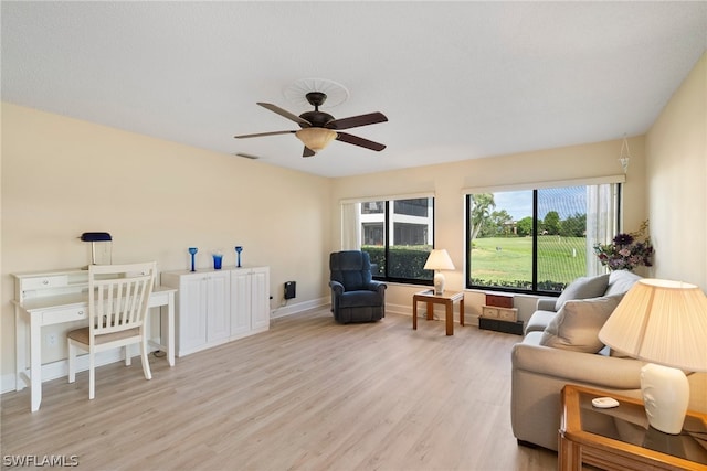 living room with a wealth of natural light, ceiling fan, and light hardwood / wood-style flooring