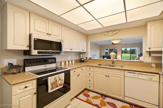 kitchen featuring white dishwasher, sink, range with electric stovetop, and light tile patterned flooring