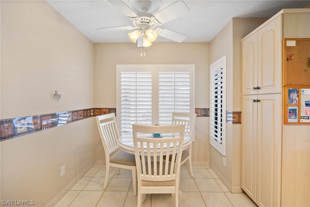 tiled dining room featuring ceiling fan and a textured ceiling