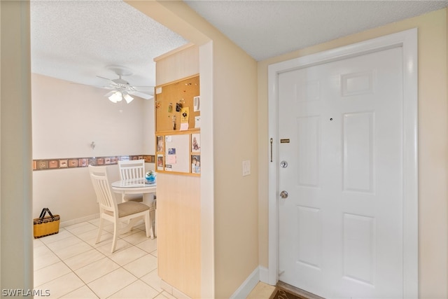 tiled entryway featuring ceiling fan and a textured ceiling