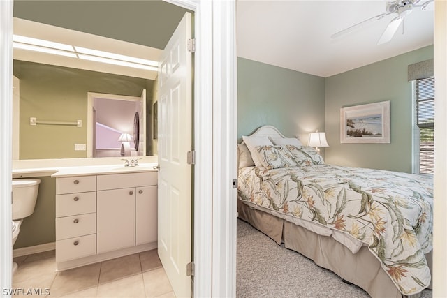 tiled bedroom with sink, connected bathroom, and ceiling fan