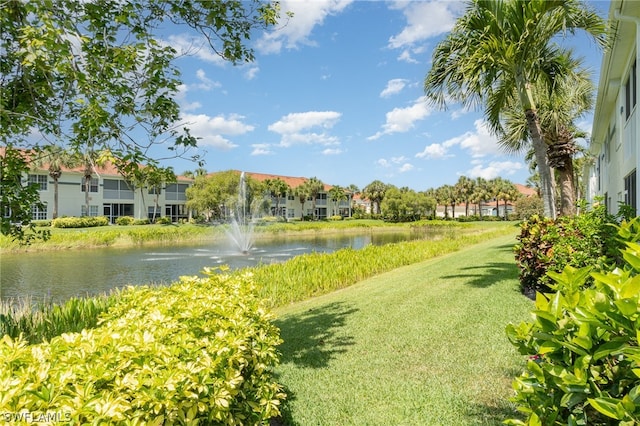 view of property's community featuring a lawn and a water view