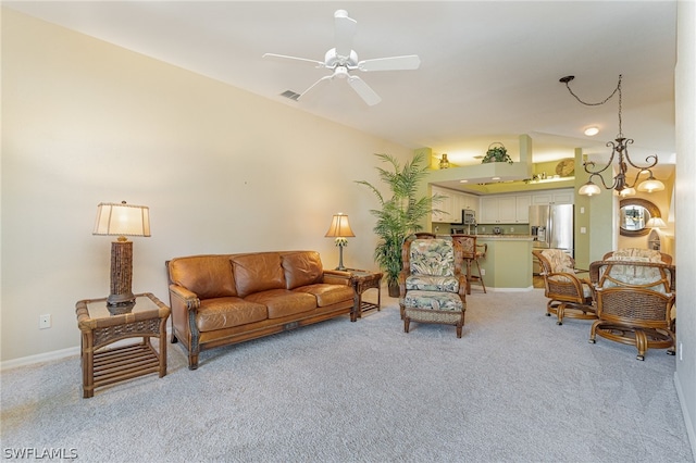 carpeted living room with ceiling fan with notable chandelier