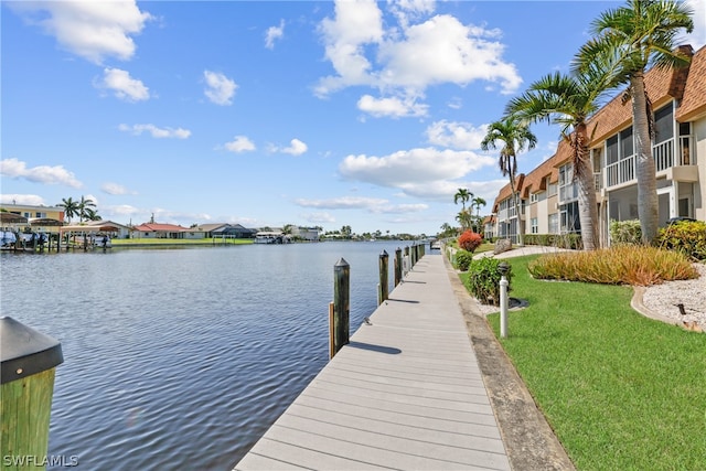 dock area with a water view and a lawn