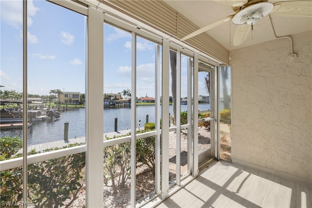 sunroom featuring a water view and ceiling fan