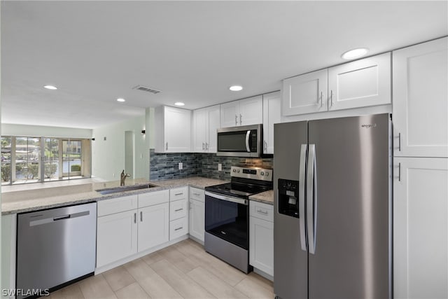 kitchen featuring sink, white cabinets, tasteful backsplash, and appliances with stainless steel finishes