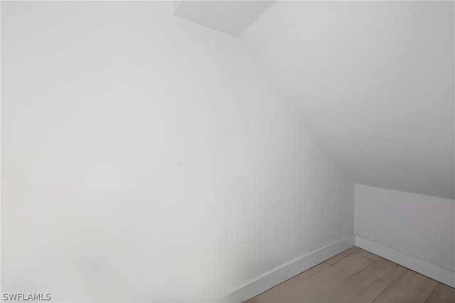 bonus room featuring vaulted ceiling and hardwood / wood-style flooring