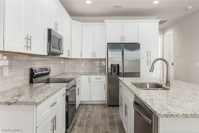 kitchen featuring white cabinets, dark wood-type flooring, backsplash, stainless steel appliances, and sink